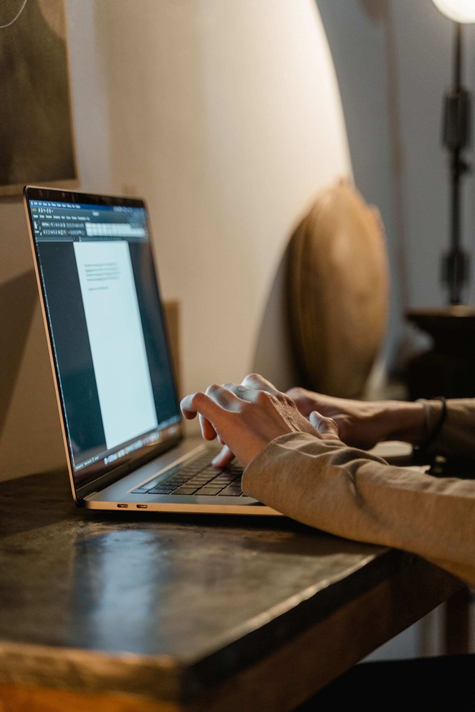 Close-up of hands typing on a laptop while filing LLC formation paperwork